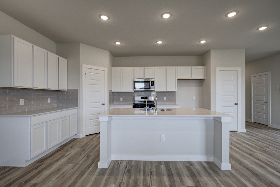 A kitchen with white cabinets.