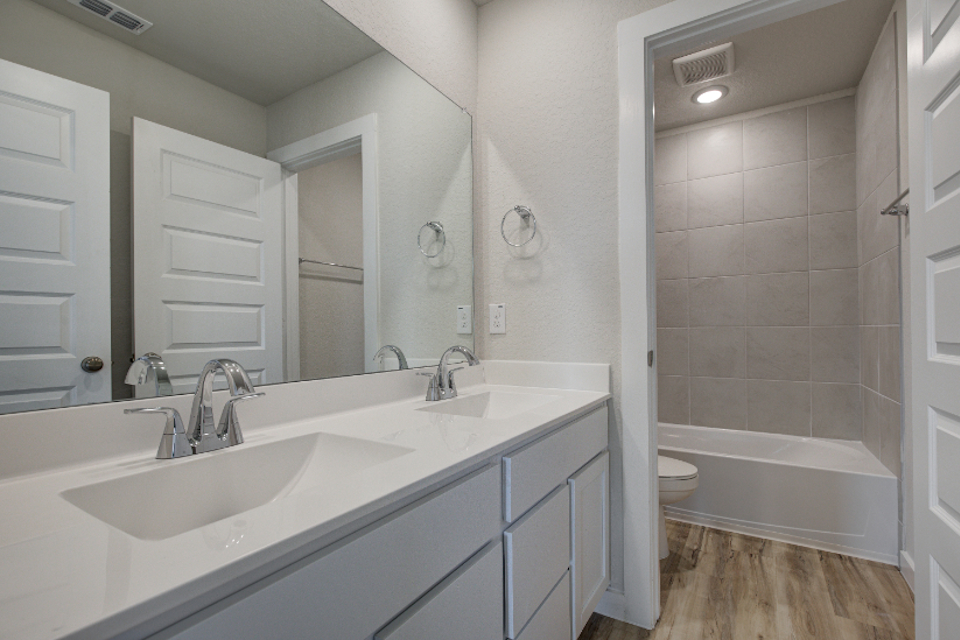 A bathroom with a tub sink and toilet.