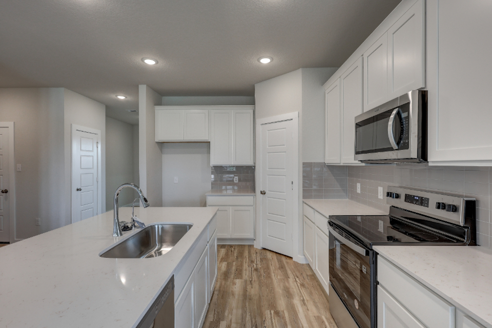 A kitchen with white cabinets.