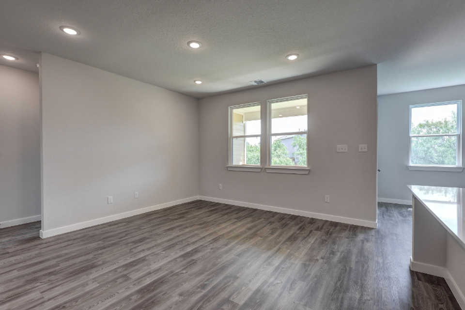 A room with windows and wood floor.
