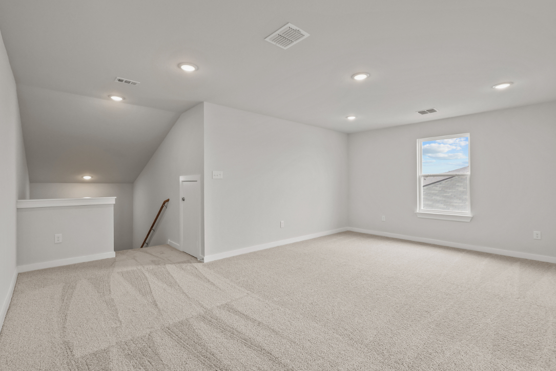 A room with a carpet and a white wall.