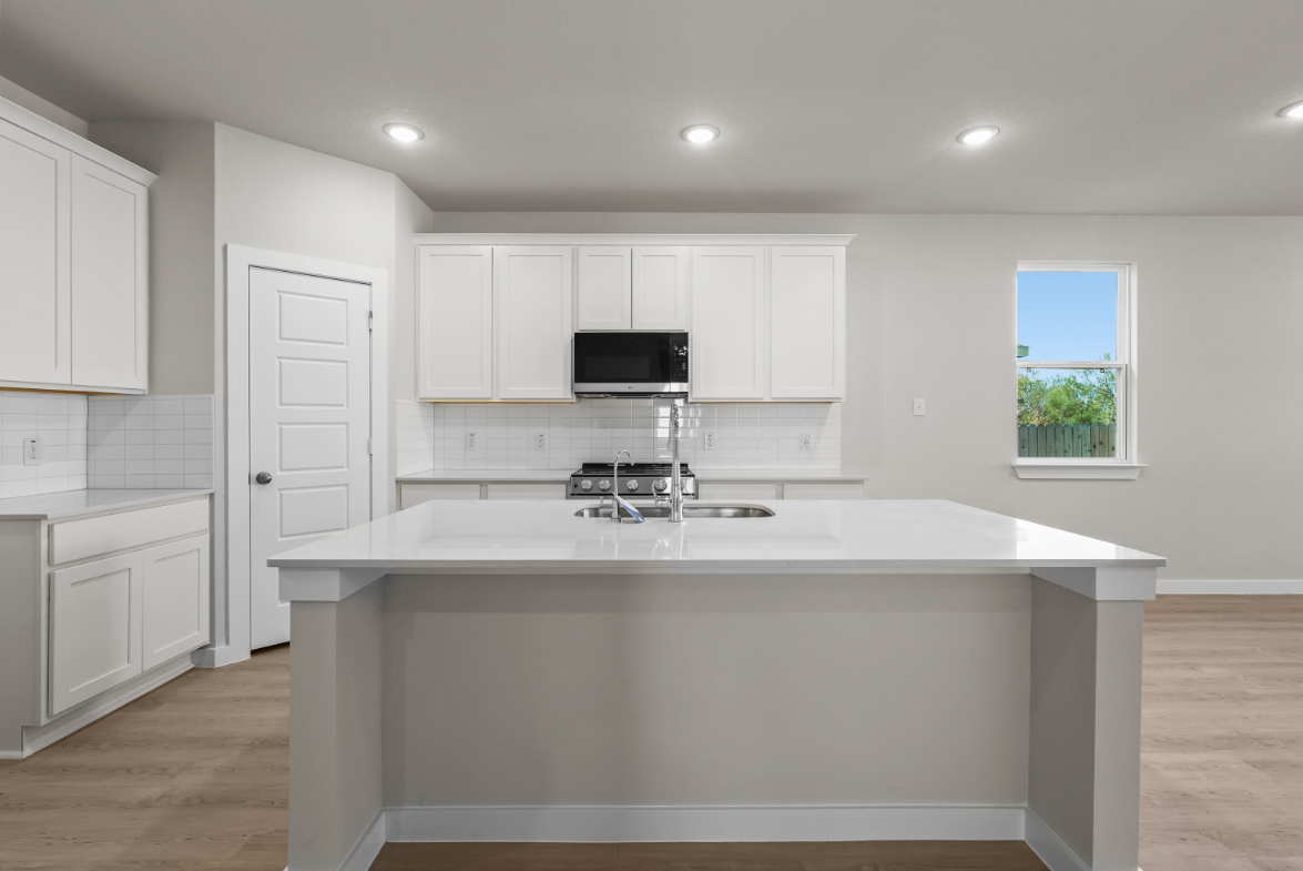 A kitchen with white cabinets.