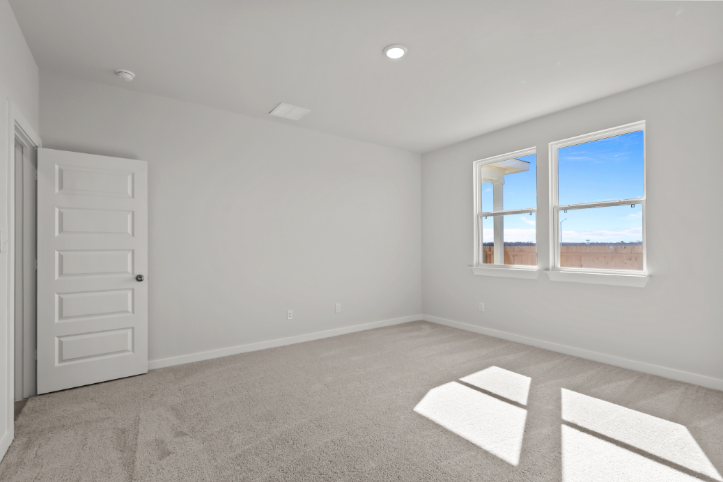 A room with a window and a rug.