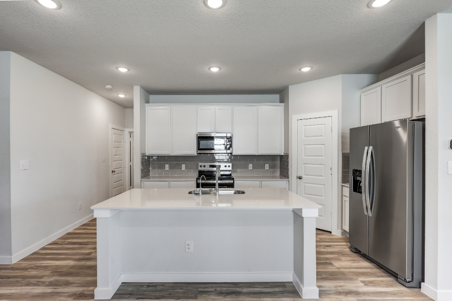 A kitchen with white cabinets.