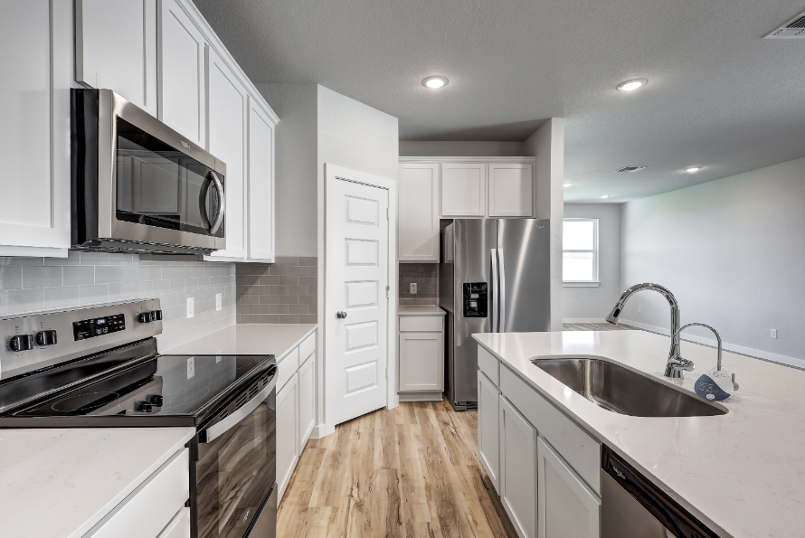A kitchen with white cabinets.