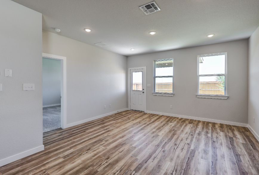 A room with a wood floor and a wood floor with a door.