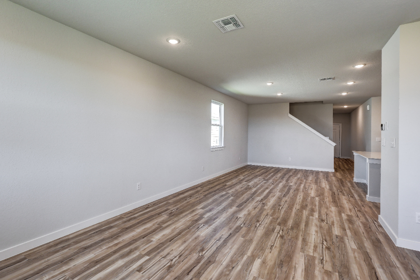 A room with a wood floor and white walls.