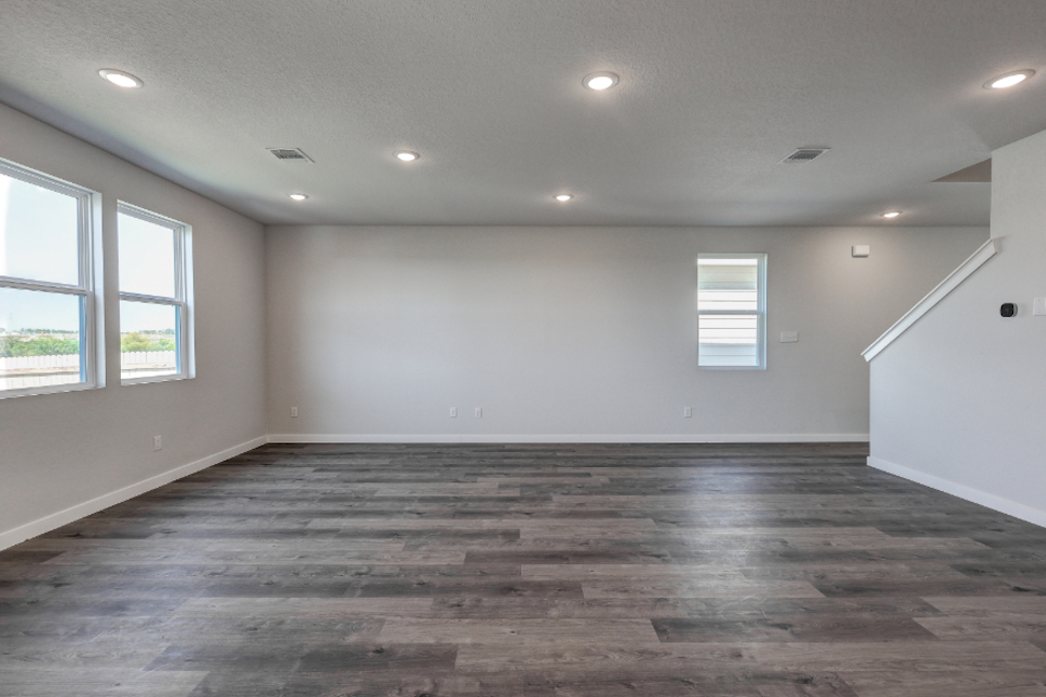 A room with windows and wood floor.