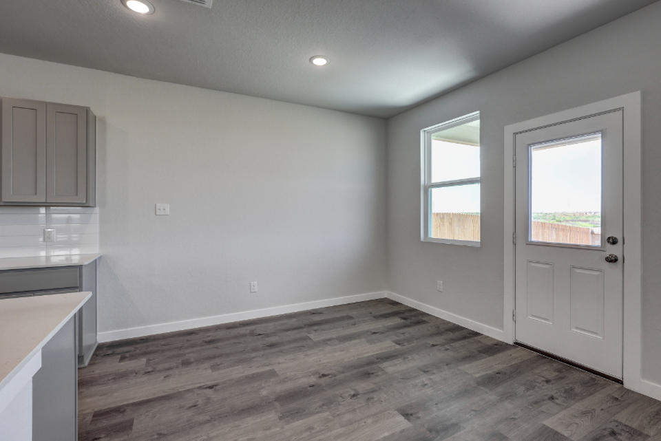 A room with a wood floor and a white door.