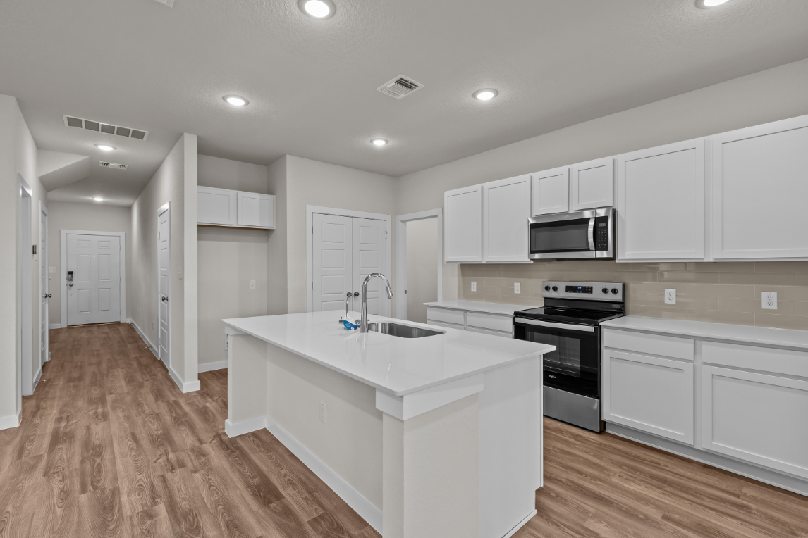 A kitchen with white cabinets.