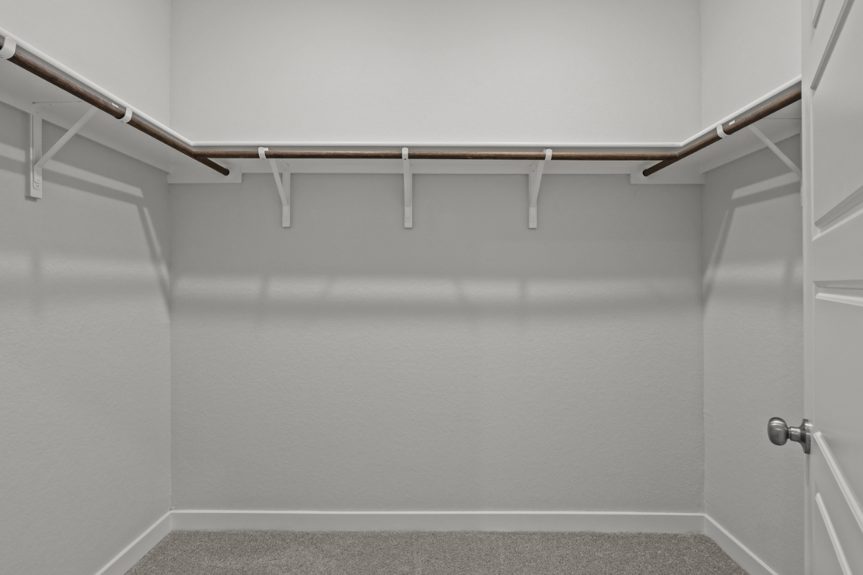 A white wall with a metal bar.