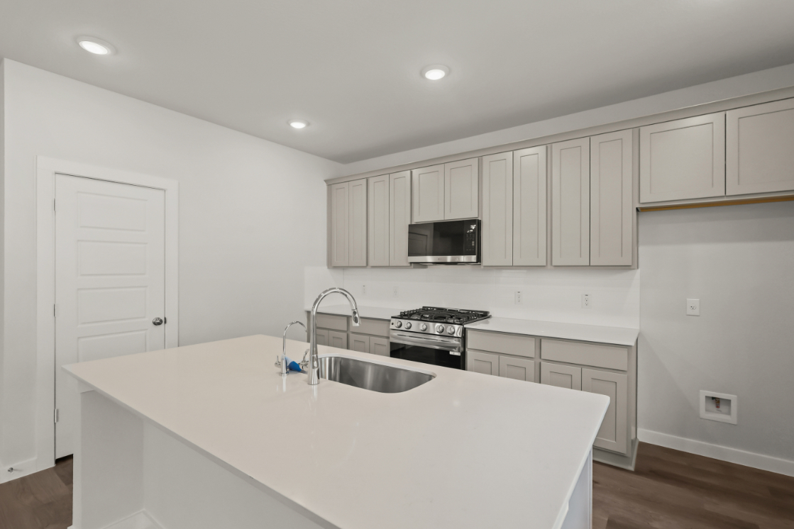 A kitchen with white cabinets.