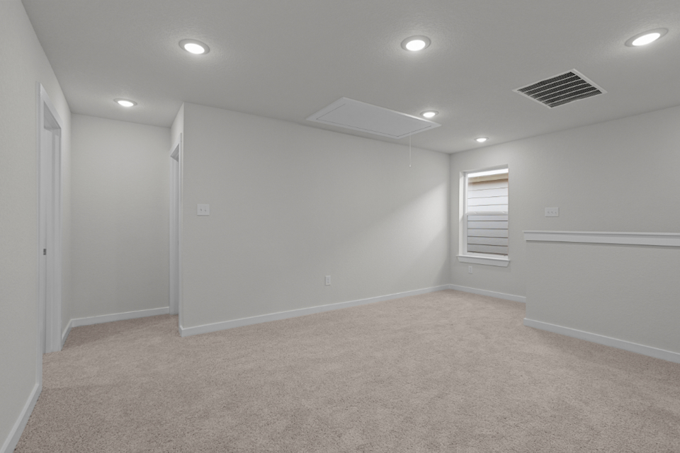 A room with a carpet and a white wall.