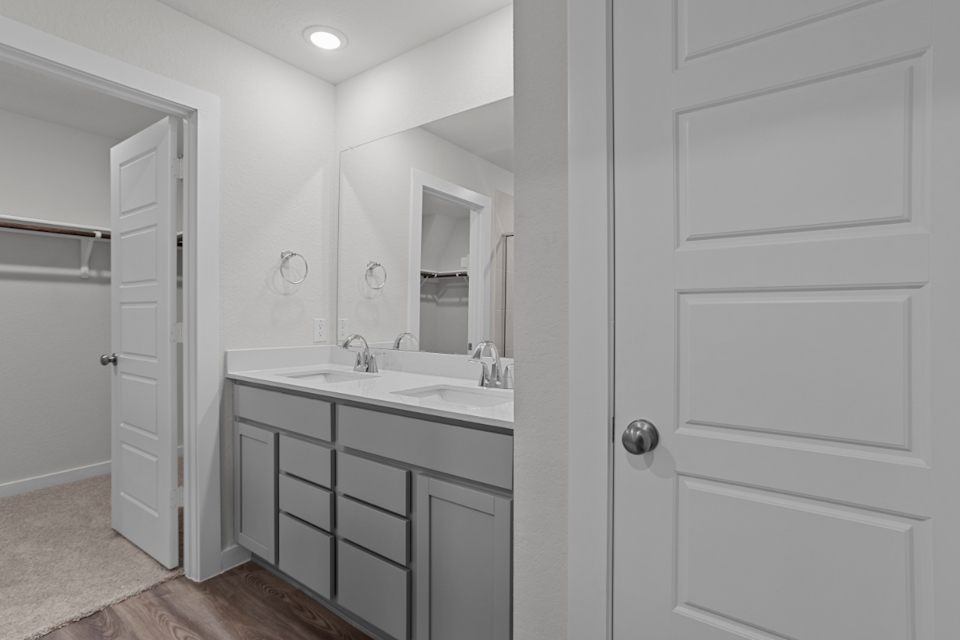 A bathroom with white cabinets.