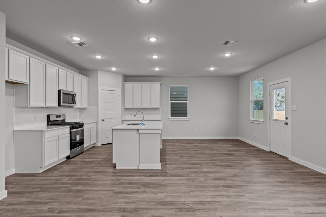 A kitchen with white cabinets.