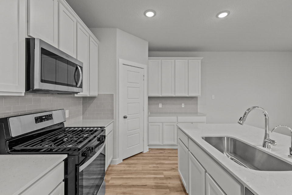 A kitchen with white cabinets.