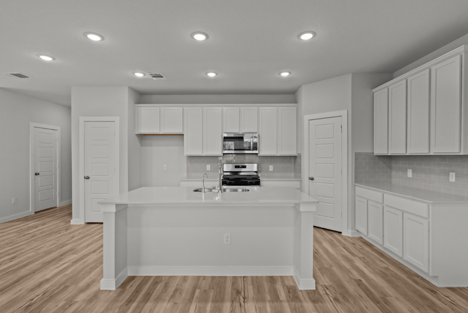 A kitchen with white cabinets.