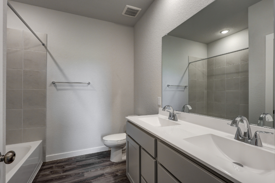 A bathroom with a tub sink and toilet.