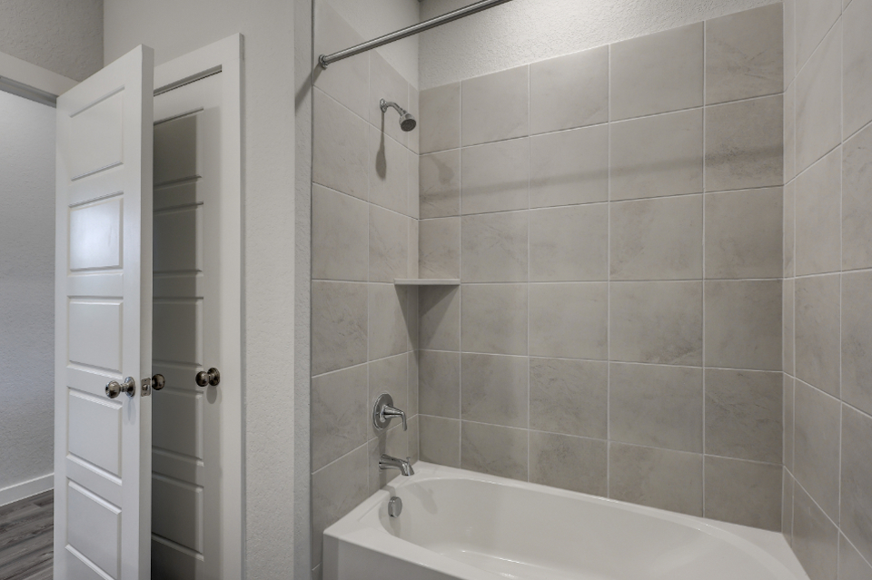 A bathroom with a bathtub and shower.