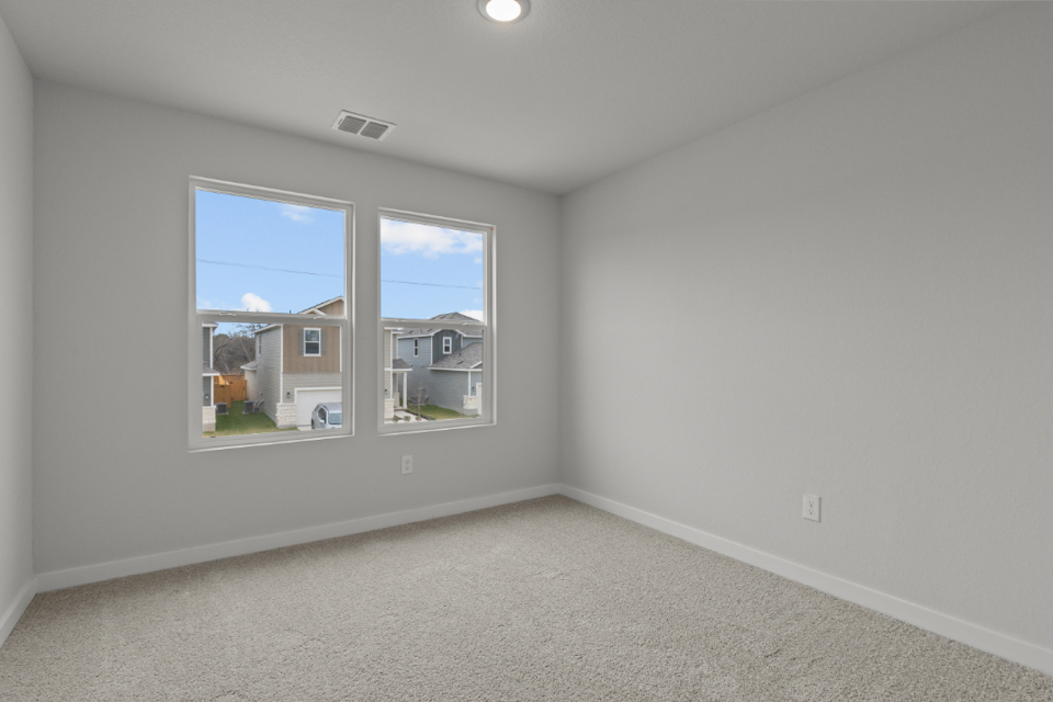 A room with a window and a carpet.