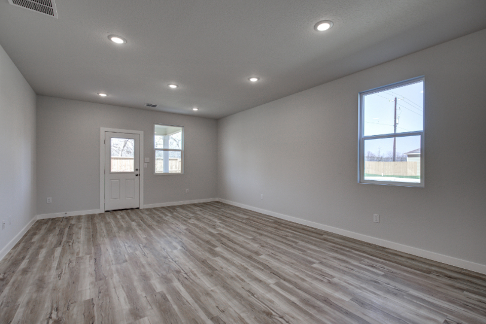 A room with a wood floor and windows.