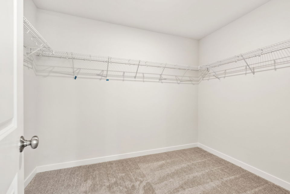 A room with a white wall and a metal bar.