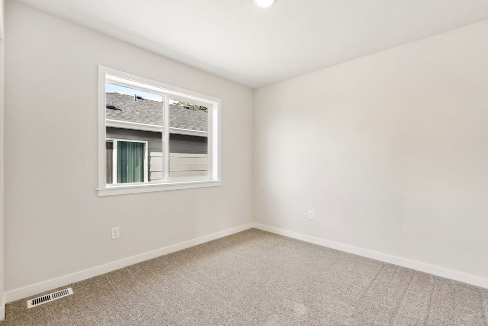 A room with a window and carpet.