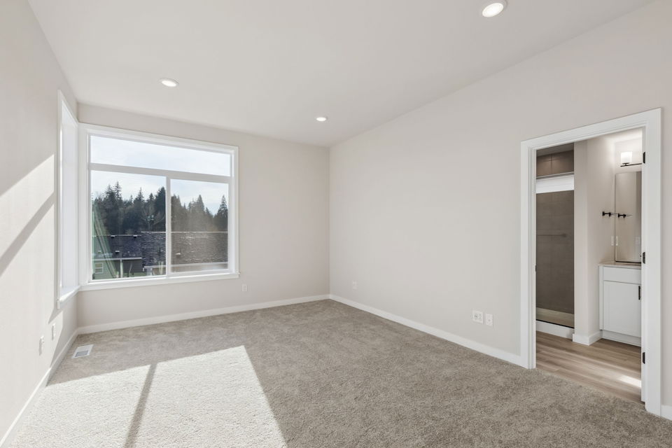 A room with a window and a rug.