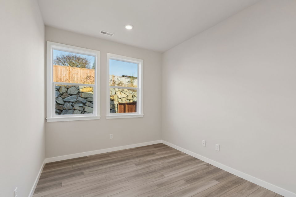 A room with a wood floor and windows.