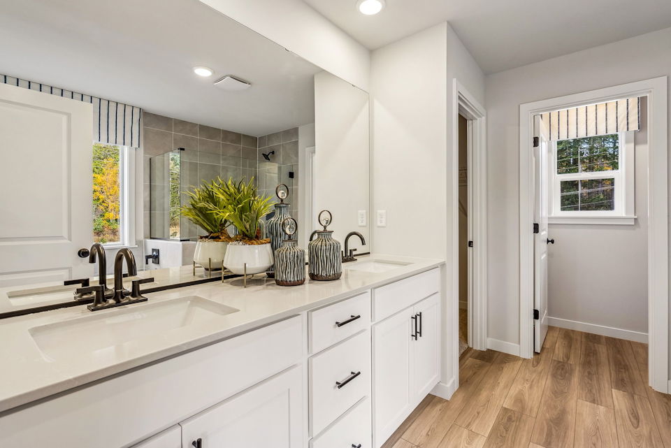 A bathroom with white cabinets.