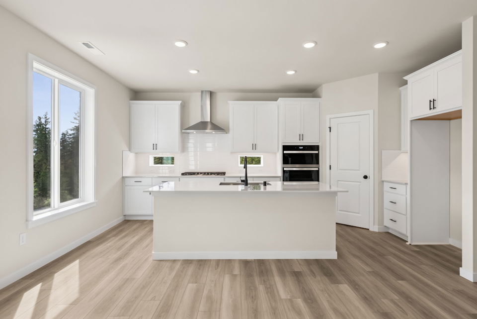 A kitchen with white cabinets.