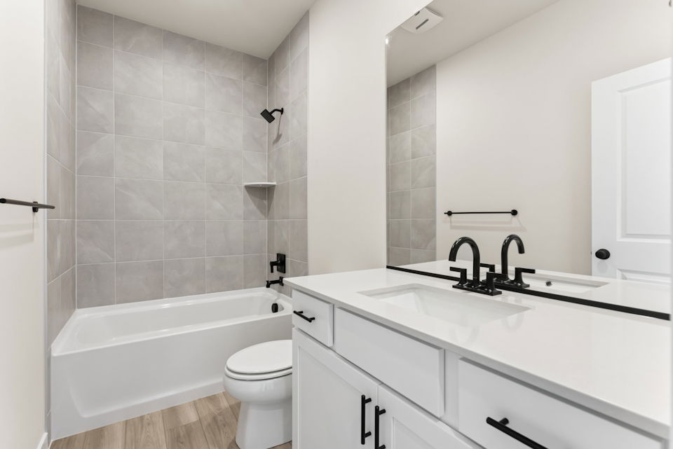 A bathroom with a tub sink and toilet.