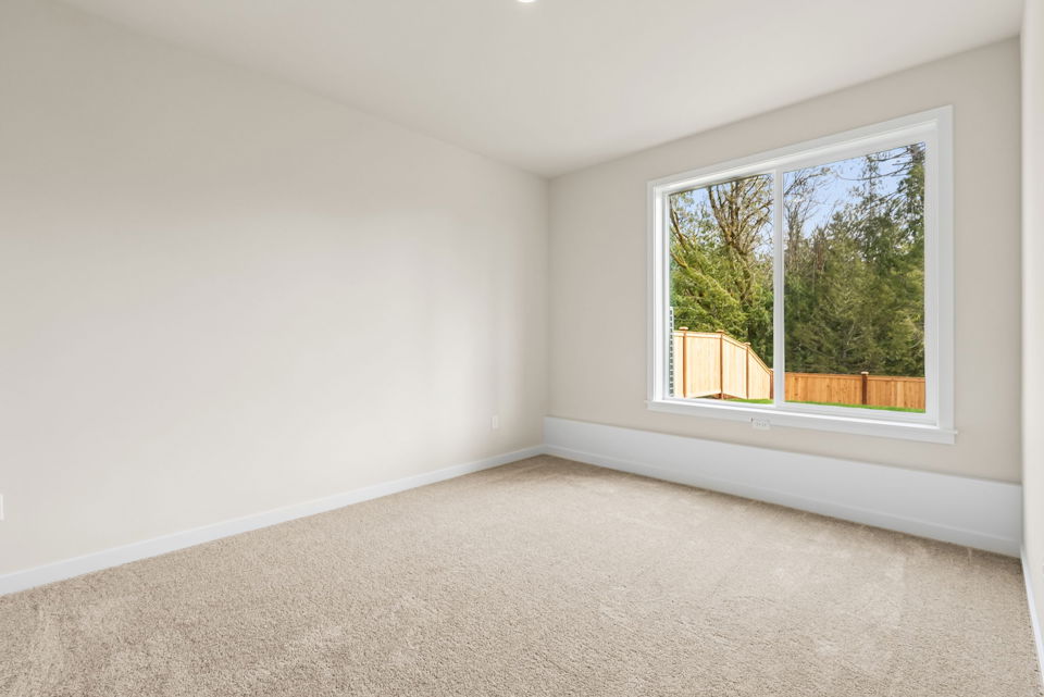 A room with a window and a carpet.
