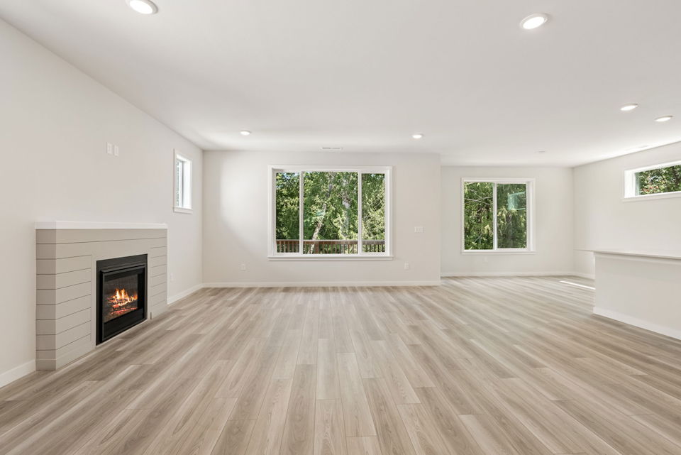 A room with a fireplace and a wood floor.