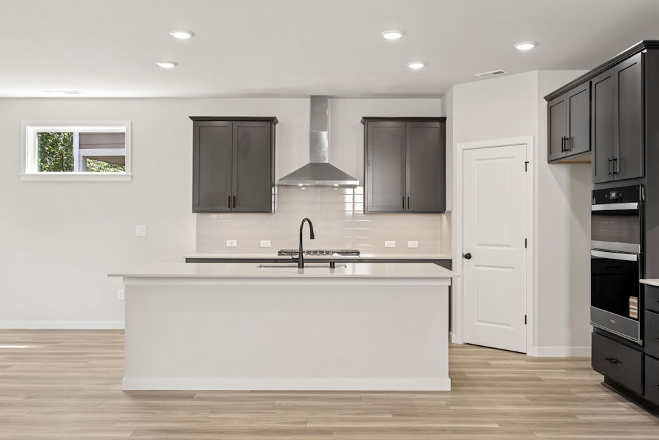 A kitchen with black cabinets.