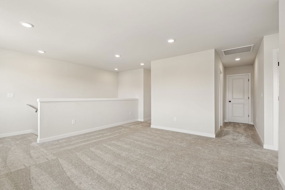 A room with a carpet and a white wall.