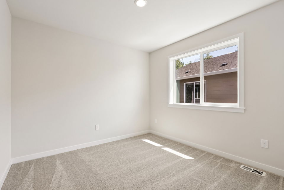 A room with a window and a carpet.