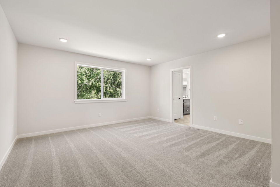 A room with a window and a carpet.