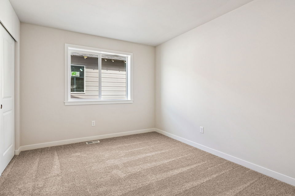 A room with a window and carpet.