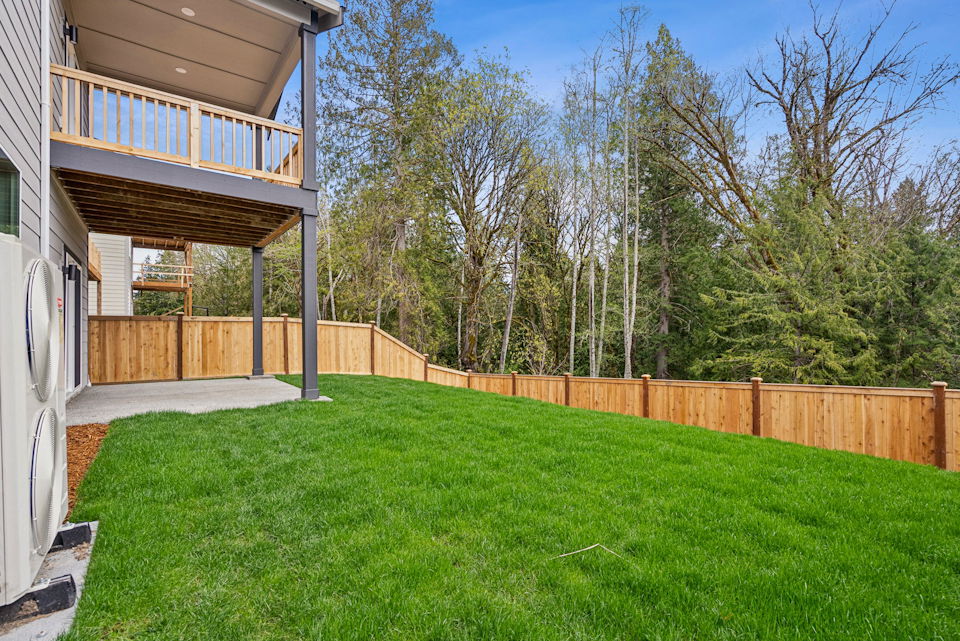 A backyard with a fence and trees.