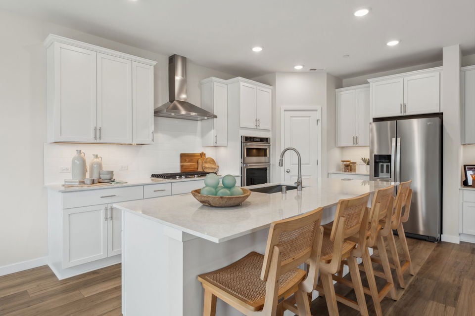 A kitchen with white cabinets.