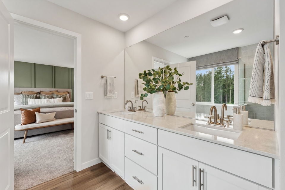 A bathroom with a tub sink and a bed.