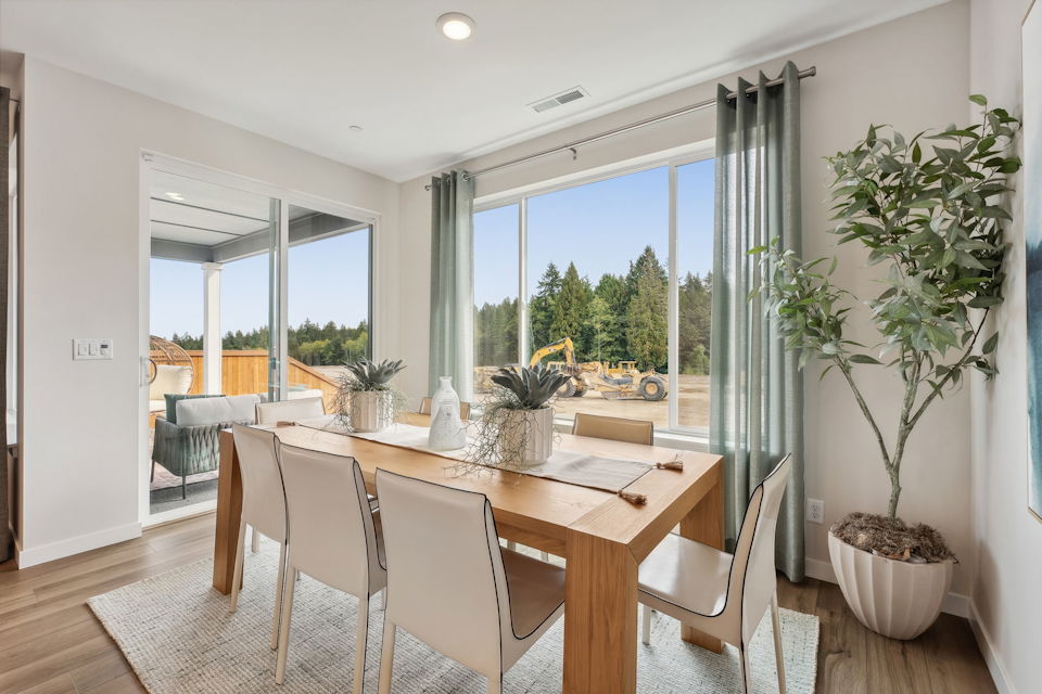 A dining room table with chairs and a large window.