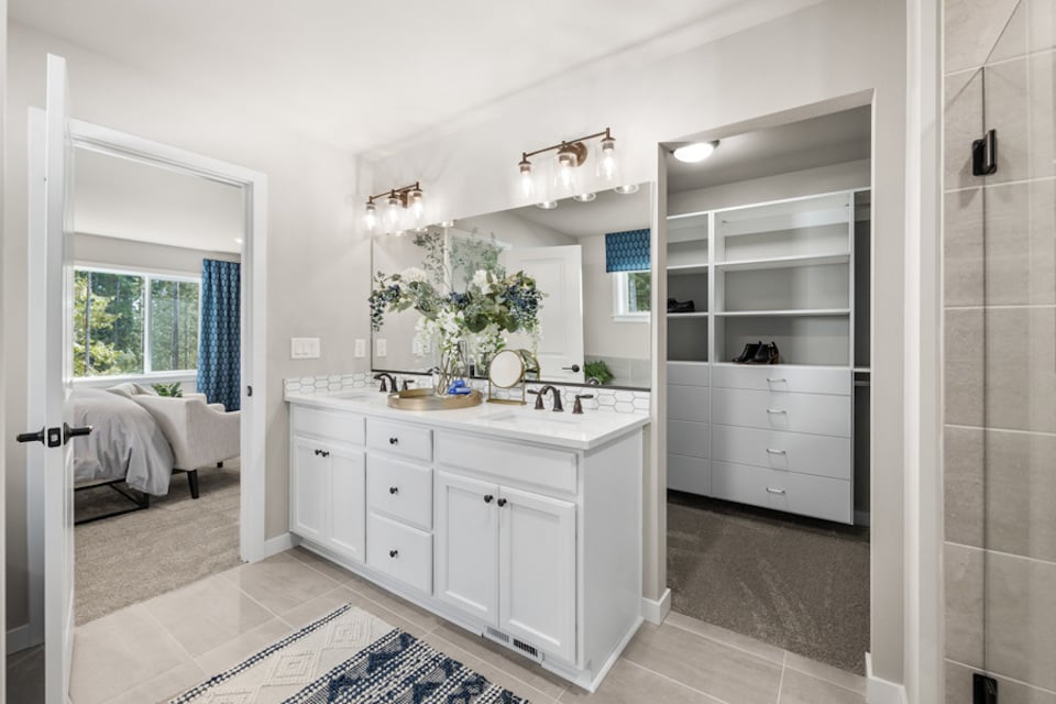 A bathroom with a sink and a bed.