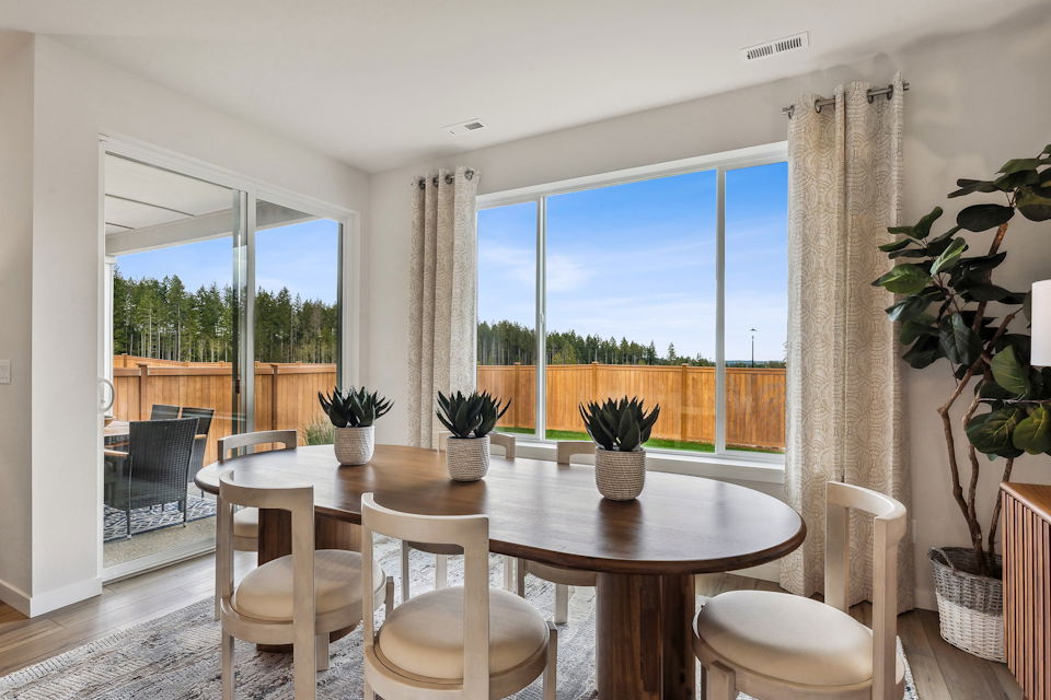 A dining room table with chairs and a large window.