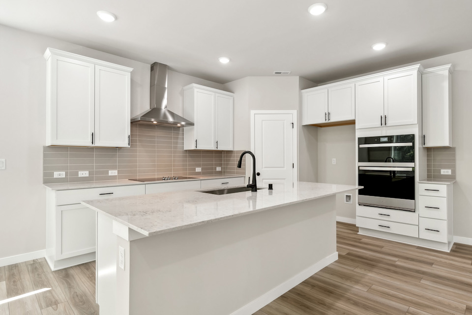 A kitchen with white cabinets.