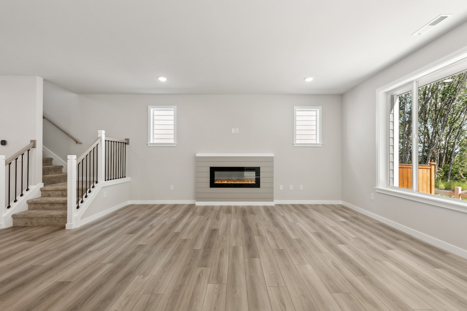 A room with a fireplace and a wood floor.