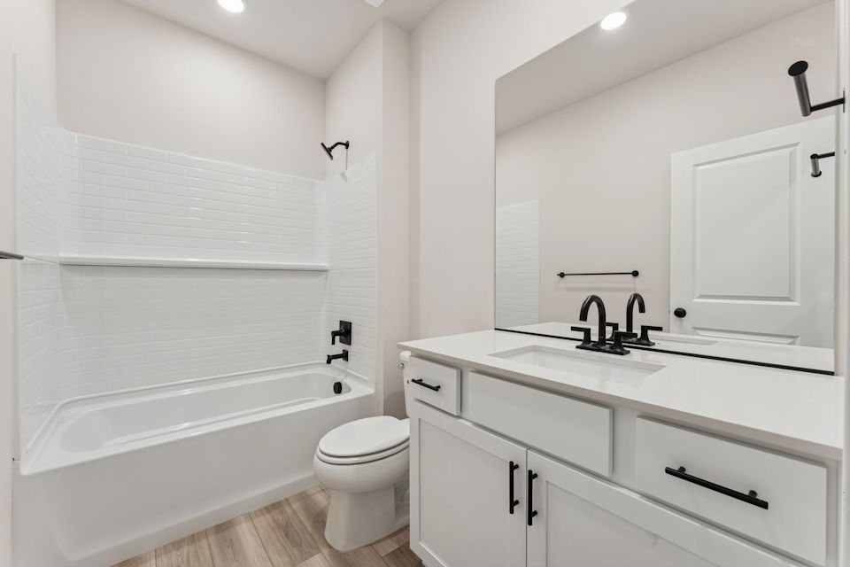 A bathroom with white cabinets.