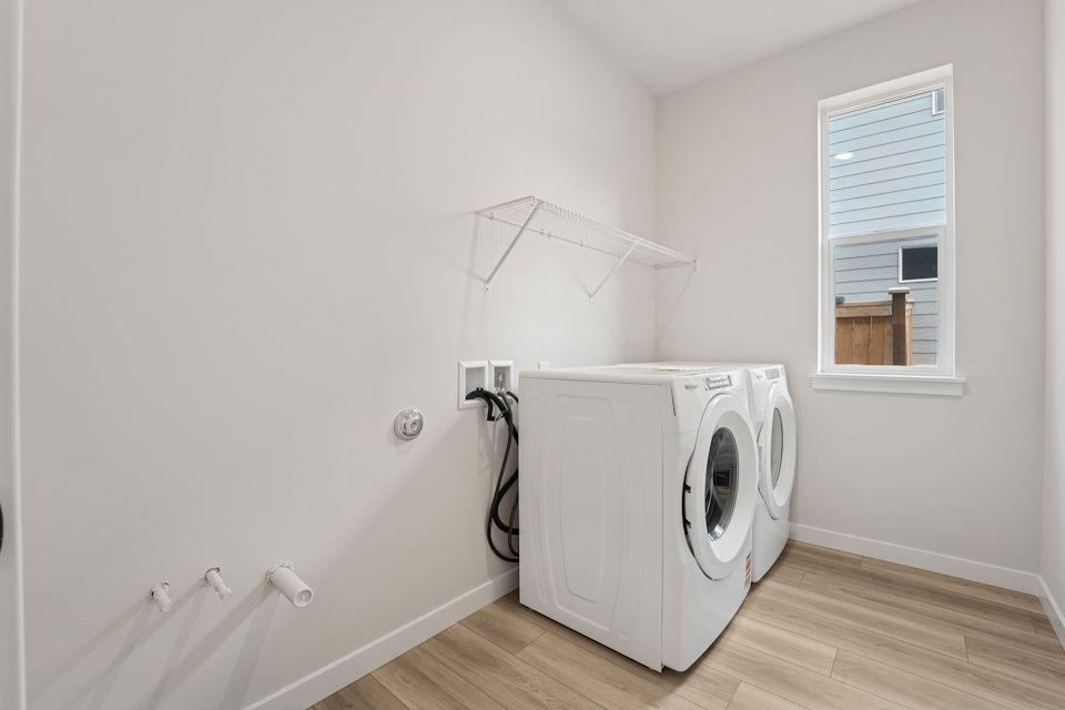 A white laundry room with a white laundry machine.