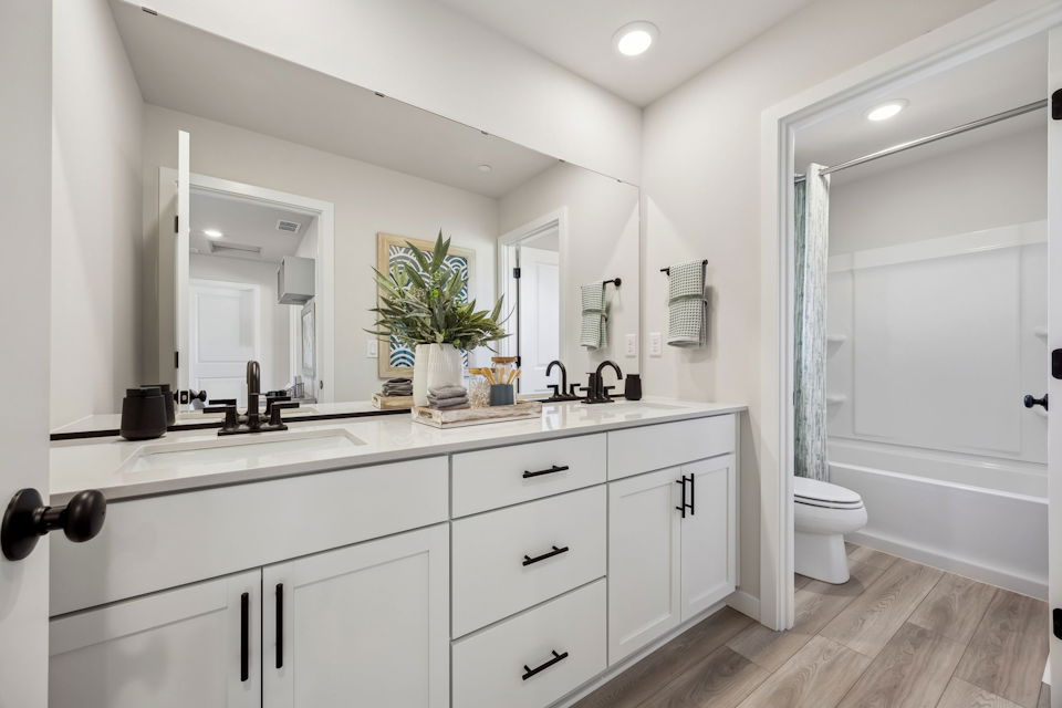 A bathroom with white cabinets.